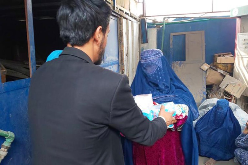 Woman in burqa receiving aid package