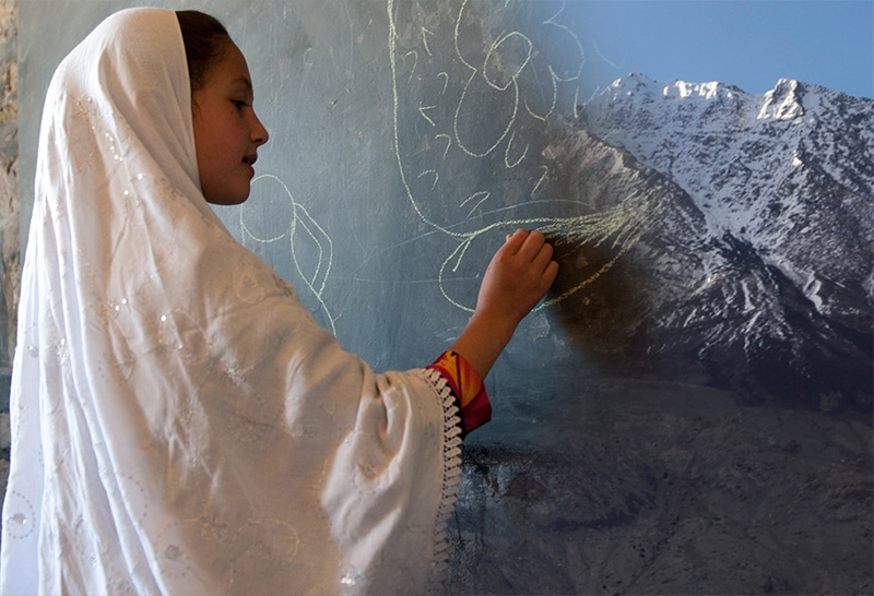 Afghan girl writing on blackboard