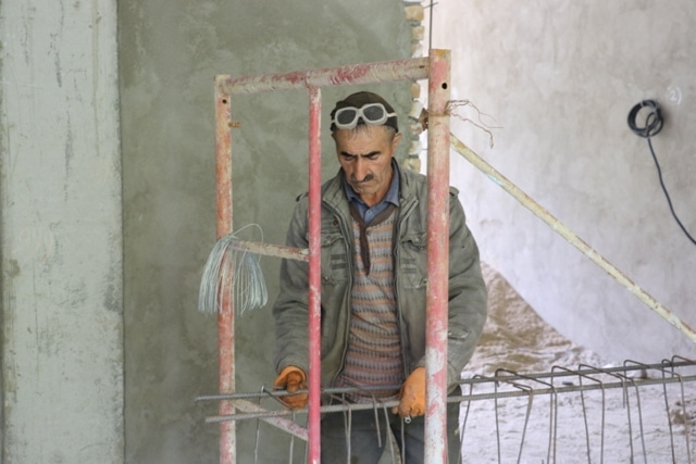 Construction progress of school in Tajikistan-man on scaffolding