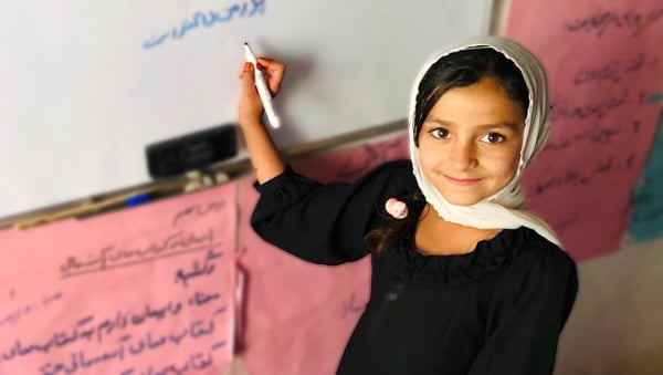 Student in Afghanistan writing on board