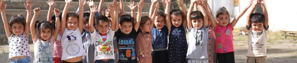 Group of preschoolers in Tajikistan raising their hands