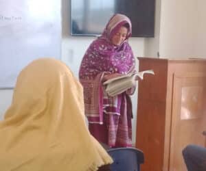 Teacher reading in front of class in Pakistan